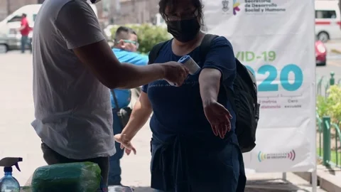 Hispanic woman getting covid temperature test in Morelia Mexico Stock Footage