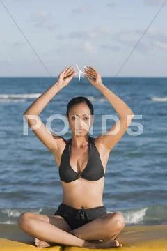 Hispanic Woman Holding Starfish Over Head