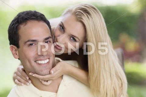 Hispanic woman kissing boyfriend's cheek Stock Photos