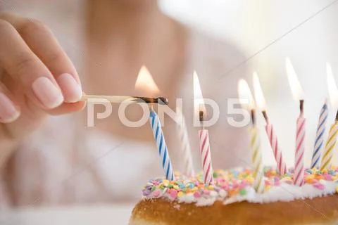 Hispanic Woman Lighting Birthday Candles