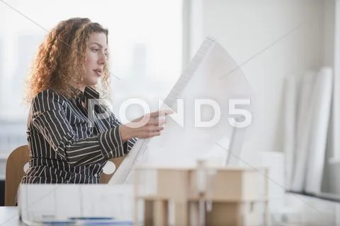 Hispanic woman looking at blueprints Stock Photos