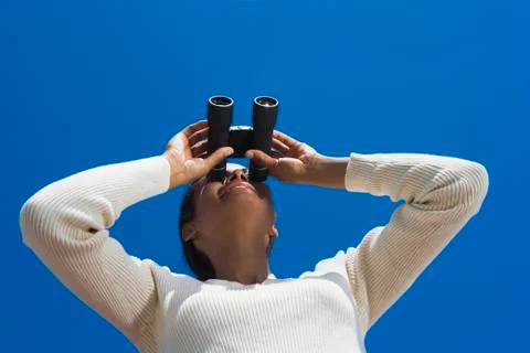 Hispanic woman looking through binoculars Stock Photos