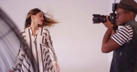 Hispanic woman model hair blowing in fan during fashion photo shoot Stock Footage