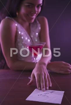 Hispanic woman offering telephone number on napkin Stock Photos
