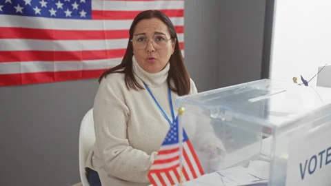 Hispanic woman overseeing voting process at a usa polling station with amer.. Video stock 276188420