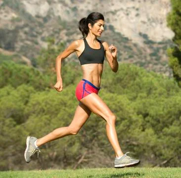 Hispanic woman running in rural field Stock Photos