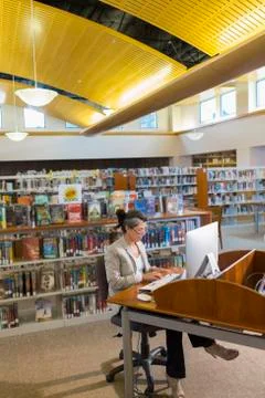 Hispanic woman using computer in library 写真素材