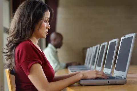 Hispanic woman using laptop at computer lab Stock Photos