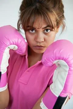 Hispanic woman wearing pink boxing gloves Stock Photos
