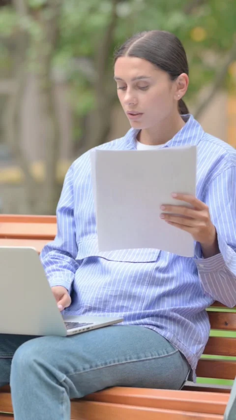 Hispanic Woman Working on Documents and Laptop Outdoor, vertical Stockbeeldmateriaal 321121780