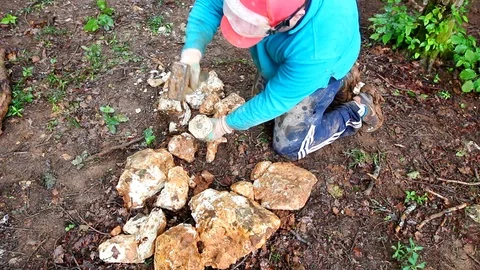 Hispanic worker drilling pebbles with a hammer and a driller. Stock Footage 109382368