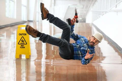 Hispanic Worker Falling on Wet Floor Stock Photos
