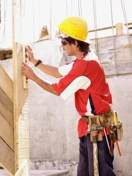 Hispanic worker using level on construction site Foto stock