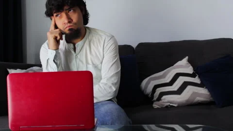 Hispanic young man in casual clothes brainstorming at a distance with a laptop Video stock 142845501