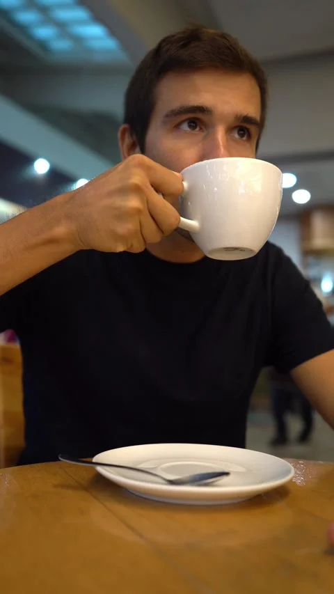 Hispanic young man drinks a cappuccino in a bar Stock Footage 163367397