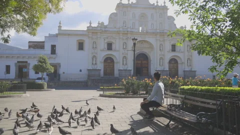 Hispanic young man sitting in the central park of Antigua Guatemala Stock Footage 147748776