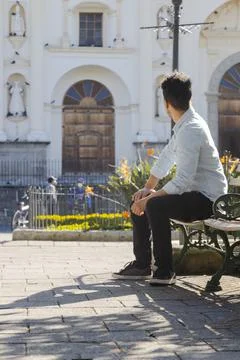 Hispanic young man sitting in central park Antigua Guatemala Stock Photos
