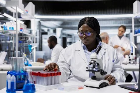 Histology technician in lab analyzing batch of blood samples Stock Photos