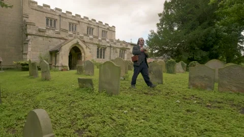 Historian Walks In Graveyard While Taking Photos On Retro Film Cameras Video stock 138673213
