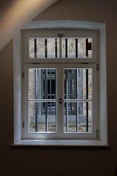 Historic barred window inside stone fortress with natural daylight. Foto stock