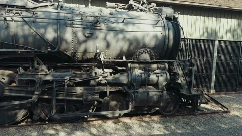 Historic black steam engine resting on a track Stock Footage 336524910