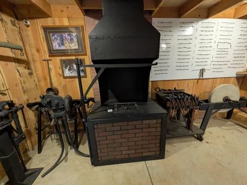 Historic blacksmith forge workshop with vintage tools, grinder 库存照片