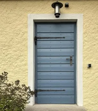 Historic Blue Door with Rustic Hardware and Textured Façade Stock Photos