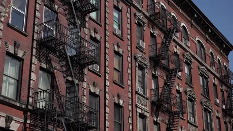 Historic brick building featuring unique fire escapes situated in urban Video stock 291636369