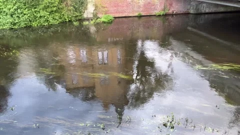 Historic Brick Building Reflected in Calm Canal Water Stock Footage 340442806