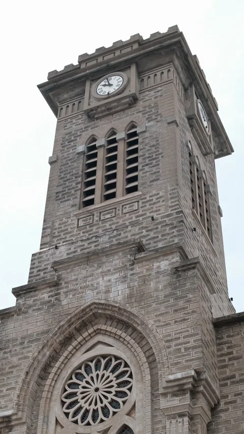 Historic brick clock tower of a gothic cathedral with a rose window 스톡 동영상 340207475