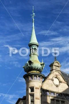 Historic building with decorative spire with blue sky and clouds Stock Photos