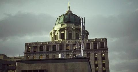 Historic building dome shines under cloudy sky in urban setting Ilustración de archivo