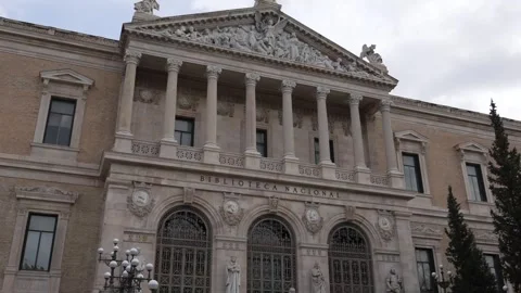 Historic building facade in Madrid with classical columns and Spanish flag Vídeos de archivo 334291237