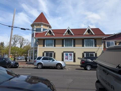 Historic building featuring a distinctive round tower, decorative siding Stockfoto's