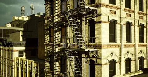 Historic building with fire escape under cloudy sky in an urban setting Stock Illustration