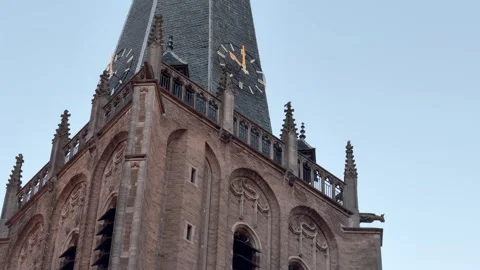 Historic Church Tower with Clock Faces Viewed from Below Against Clear Blue Sky Stock Footage 339640470