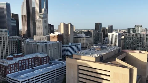 A historic clock tower among downtown Dallas rooftops at golden hour aerial Vidéo 342502295
