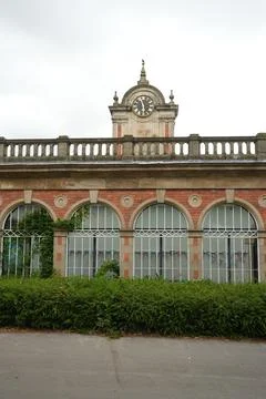 Historic Clock Tower Building At Derby Arboretum, England With Arched Windows. Stock Photos