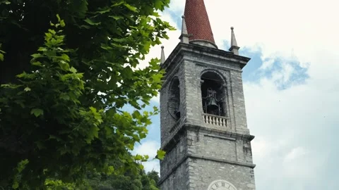 A historic clock tower in Italy, surrounded by trees and blue skies. Stock Footage 314424667