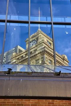 Historic Clock Tower Reflection in Modern Glass Building Perspective 스톡 사진