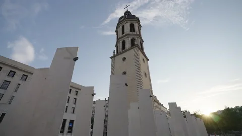 A historic clock tower , stands among modern white pillars 動画素材 304121815