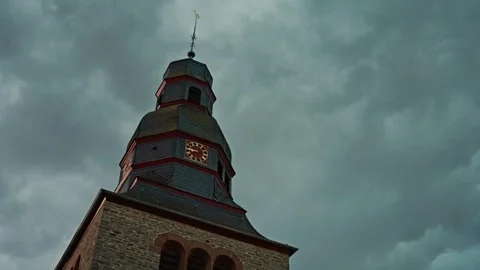 Historic Clock Tower Under Dramatic Cloudy Sky, an iconic landmark in a moody Video stock 303597871