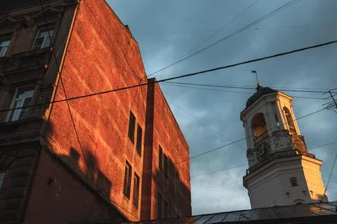 Historic clock tower of Vyborg old town rises beside a red brick building Stock Photos