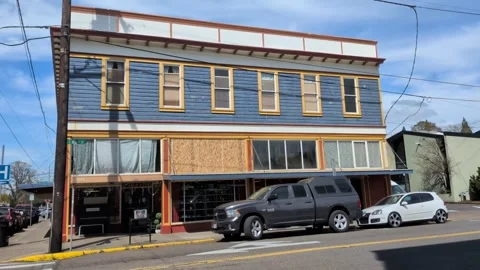 Historic commercial building with boarded upper windows and active storefront Stock-Footage 337137285