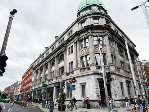 Historic domed corner building with clock and shops on a busy Dublin, Irela.. Photos