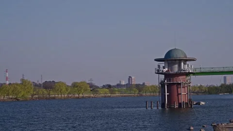 Historic Domed Intake Tower Mid-River with Spring Willows and Suburban Skyline Stock-Footage 337975274