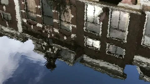 Historic Dutch building facades reflect ripple in water Stock Footage