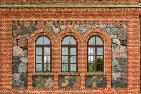 Historic facade features a combination of brick and stone with three arched.. Foto stock