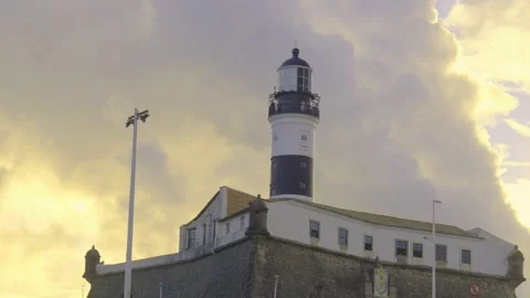 Historic Farol da Barra lighthouse and fort under golden sunset sky in Salvador  Видео 319206977