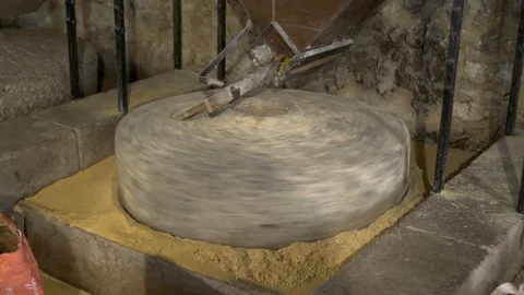 Historic hand-driven millstone grinding wheat - wide shot Stock-Footage 94194765